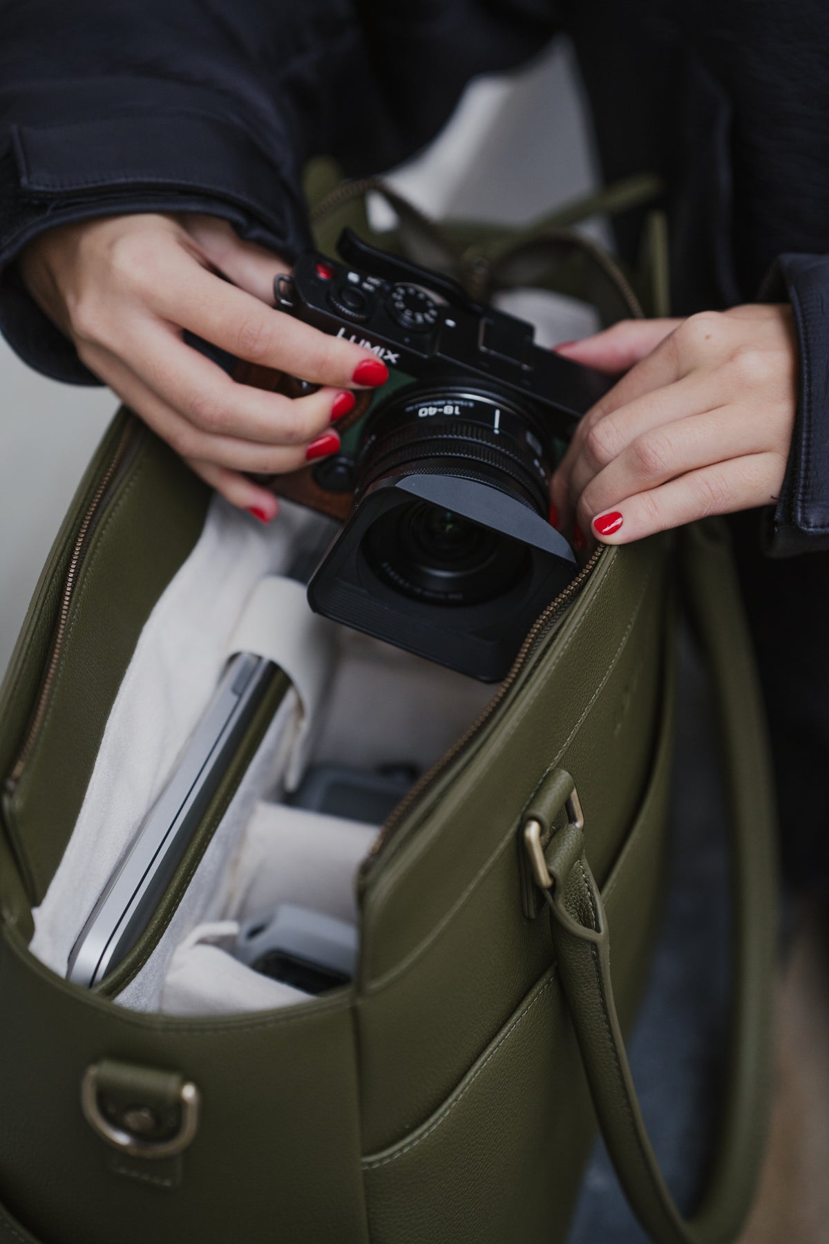 Person retrieving a camera from an open green bag