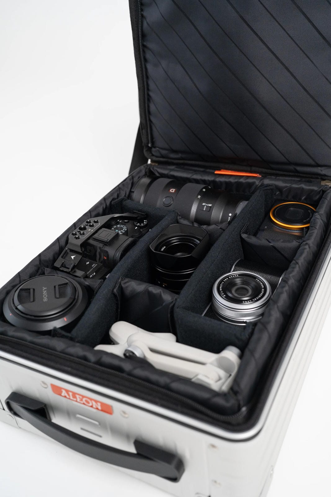 Camera equipment neatly arranged inside an open suitcase with a visible brand logo.