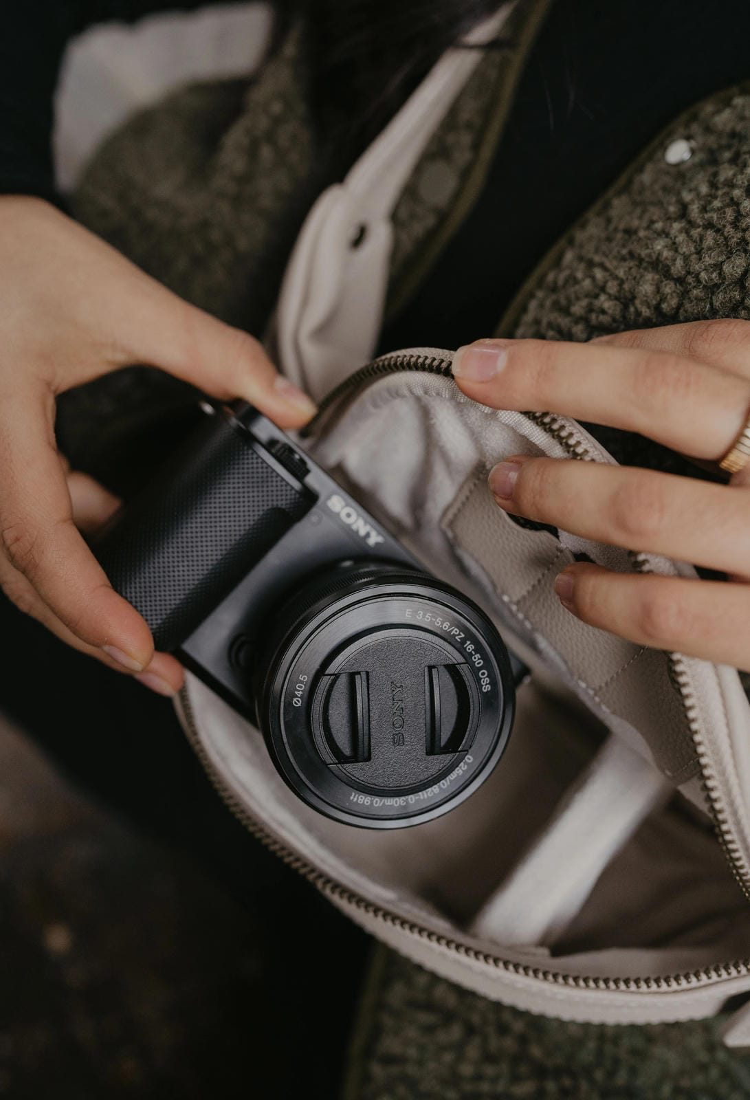 Person opening a bag to reveal a camera inside