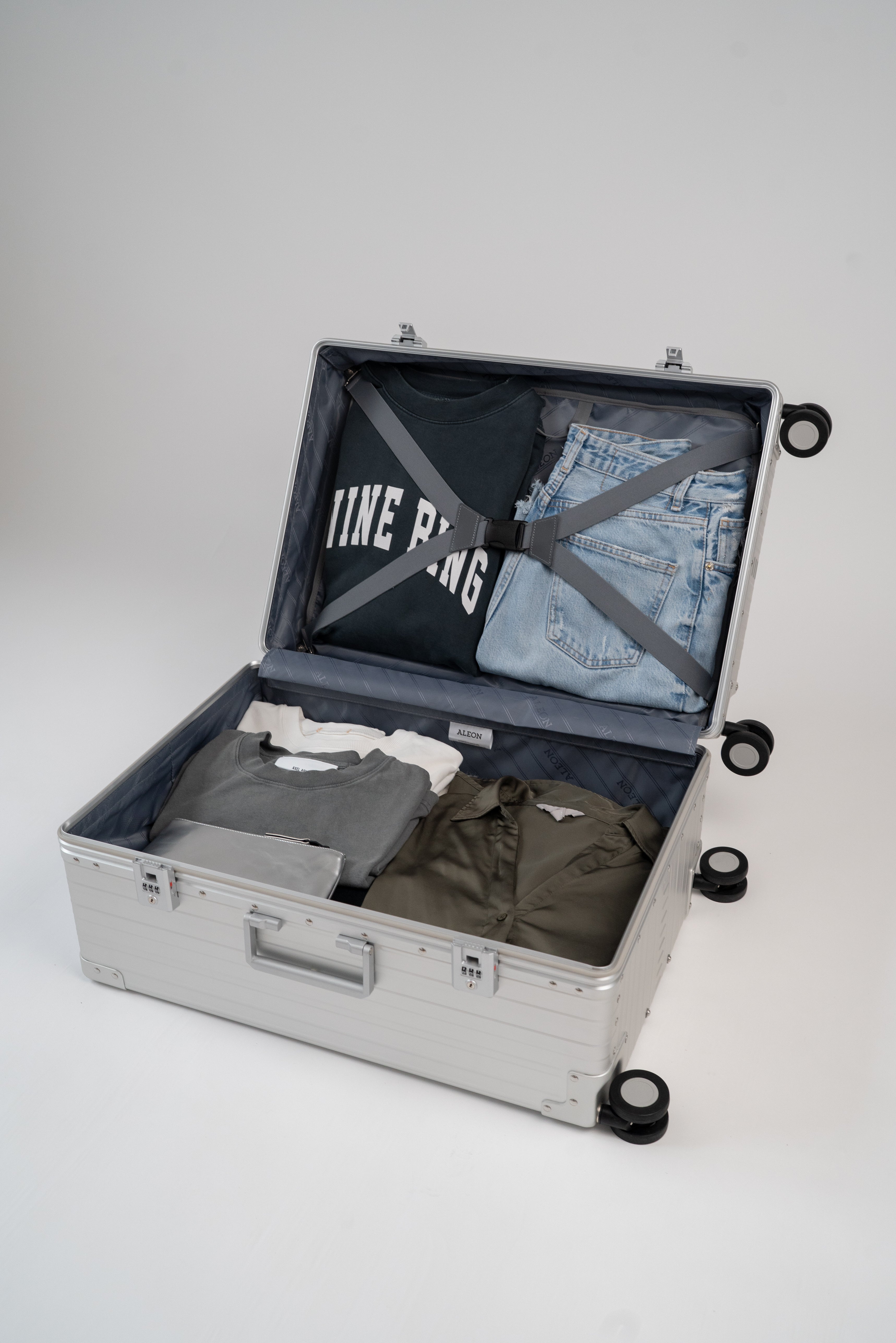 Open suitcase with clothes on a white background