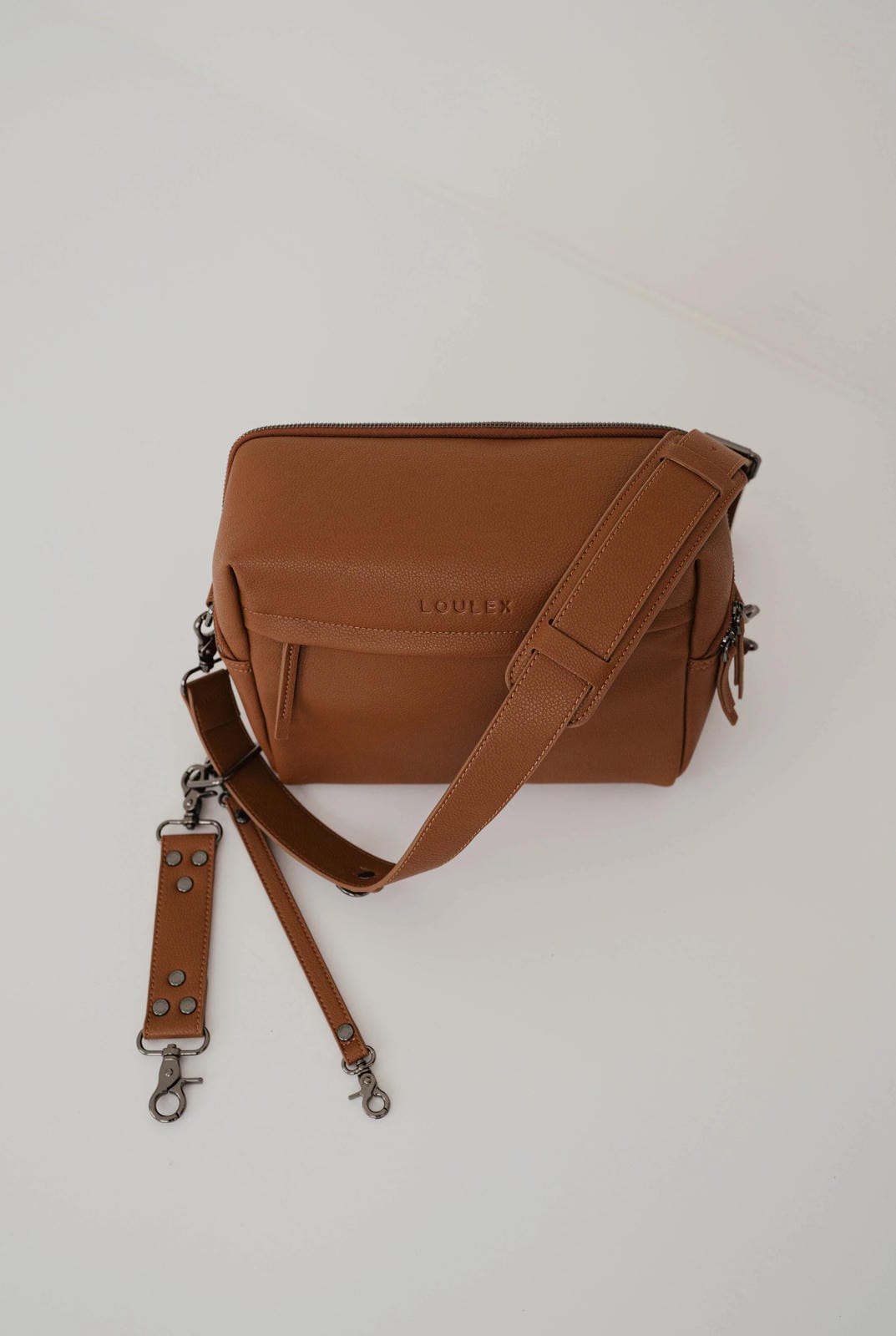 Brown leather bag with a strap on a white background