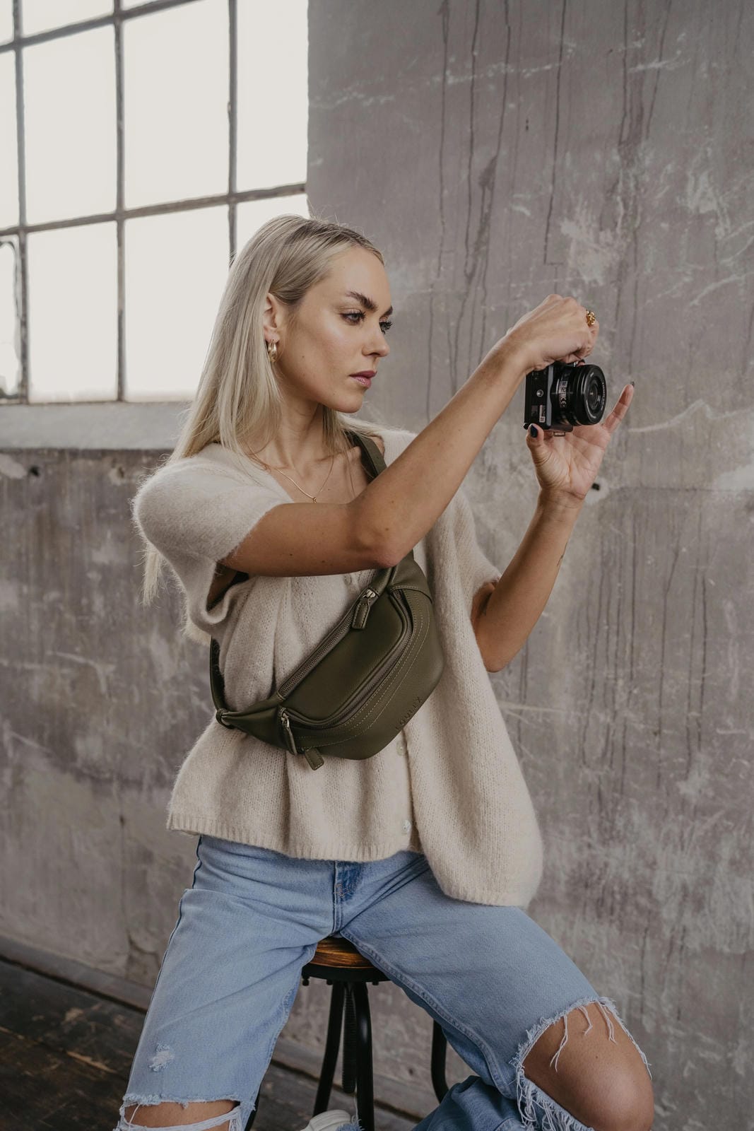Woman taking a photo with a camera in an urban setting