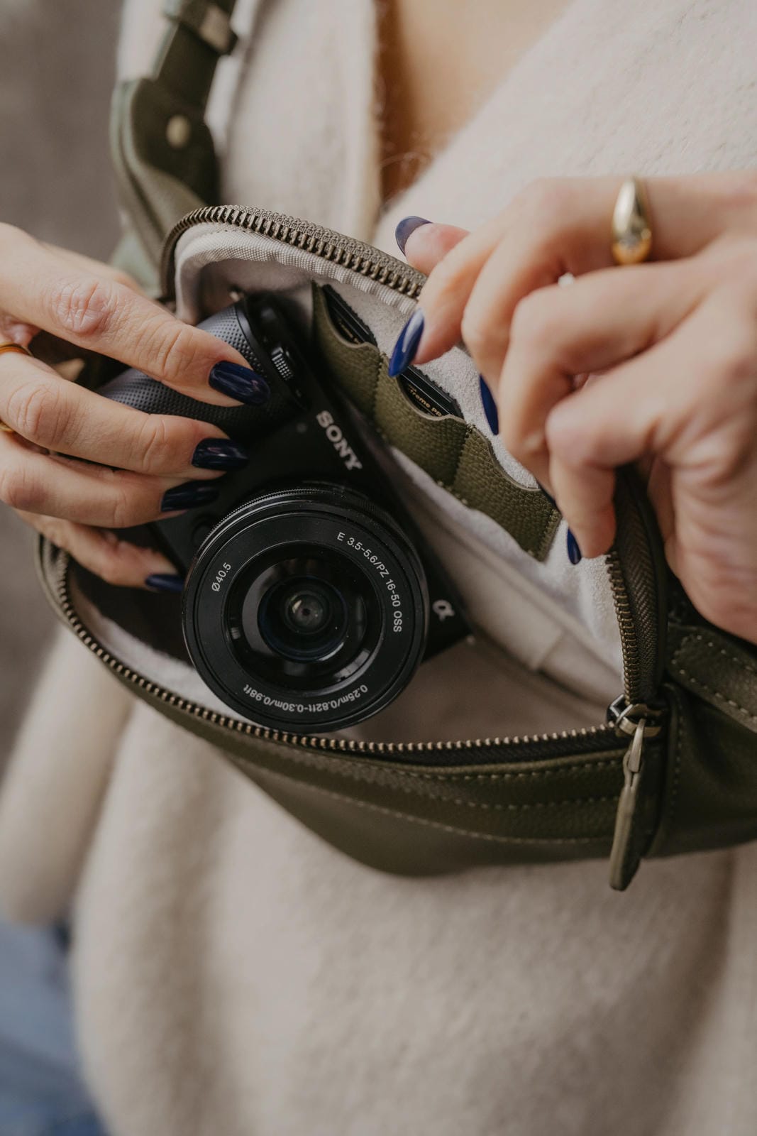 Person opening a green bag to reveal a camera
