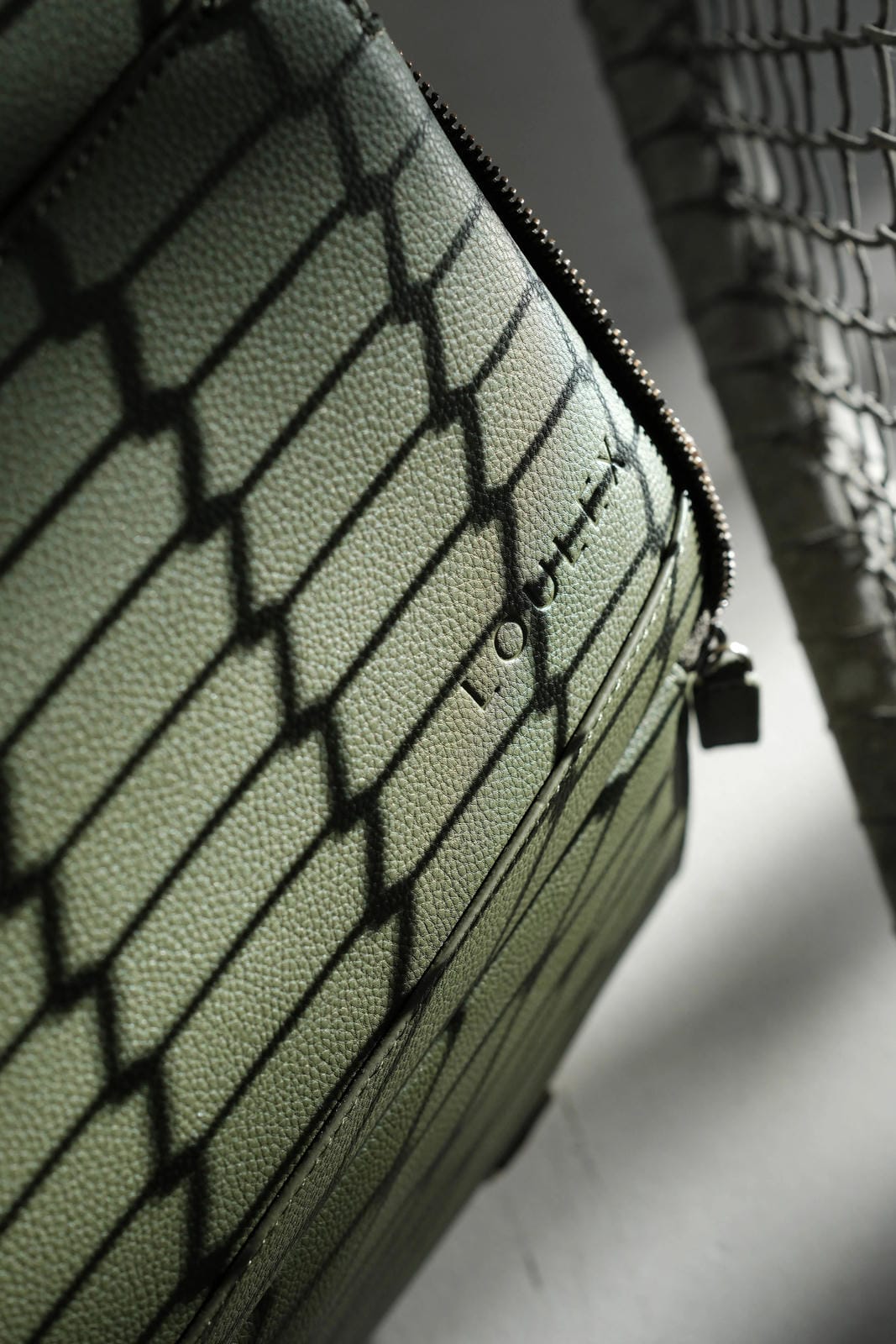 Green textured bag with a brand logo on a neutral background