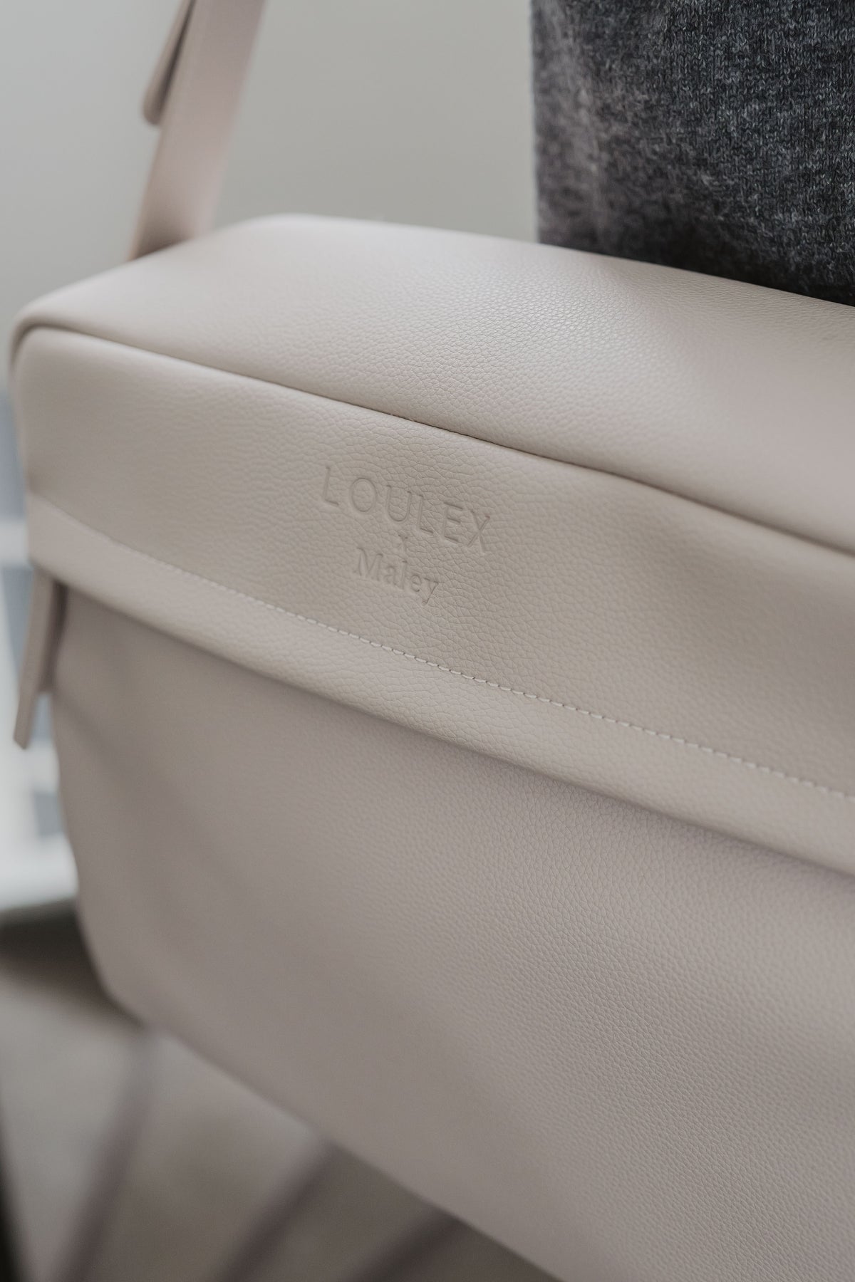 Beige bag with 'LOULEX' branding on a blurred background