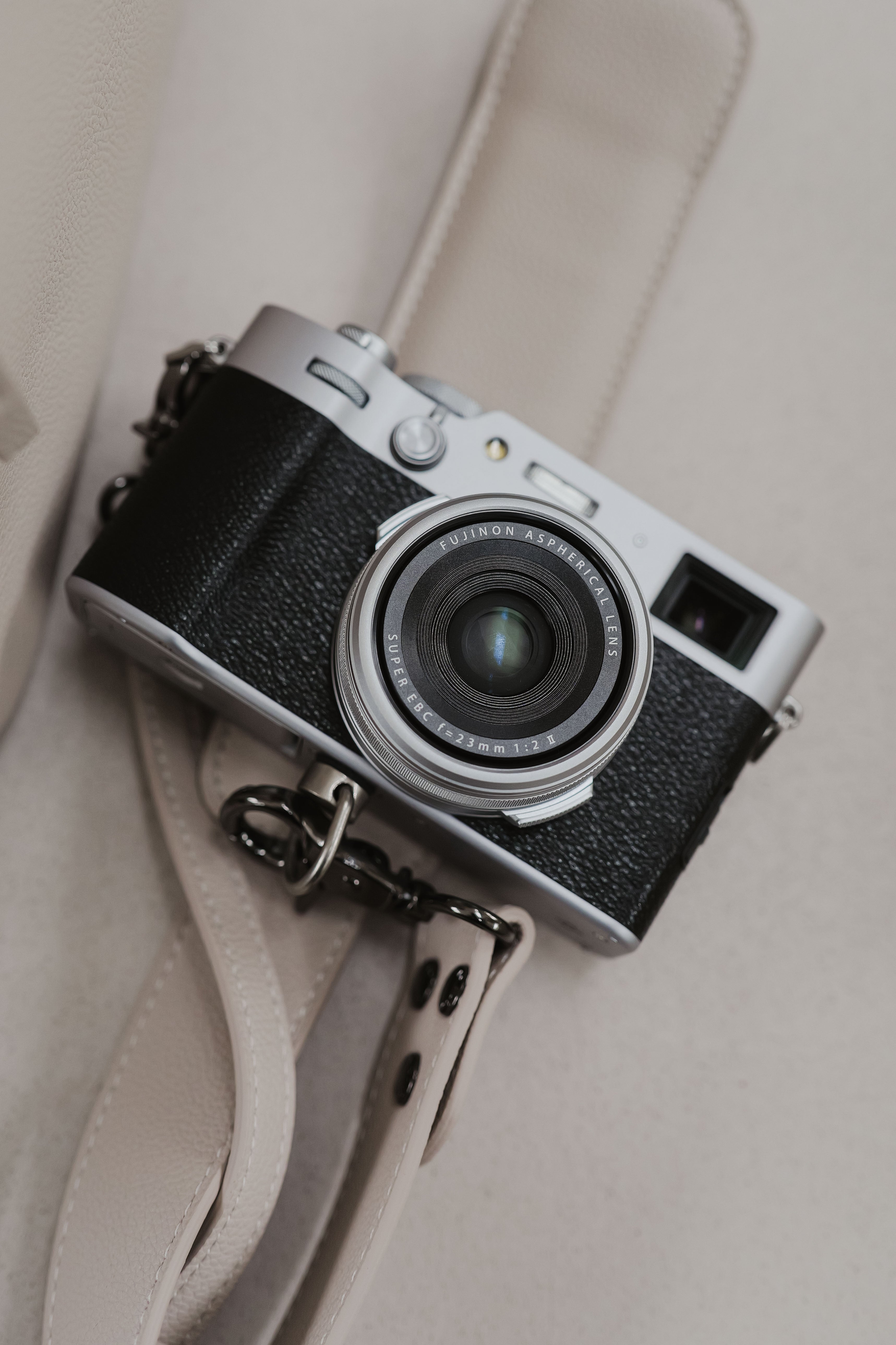 Vintage camera with a strap on a neutral background