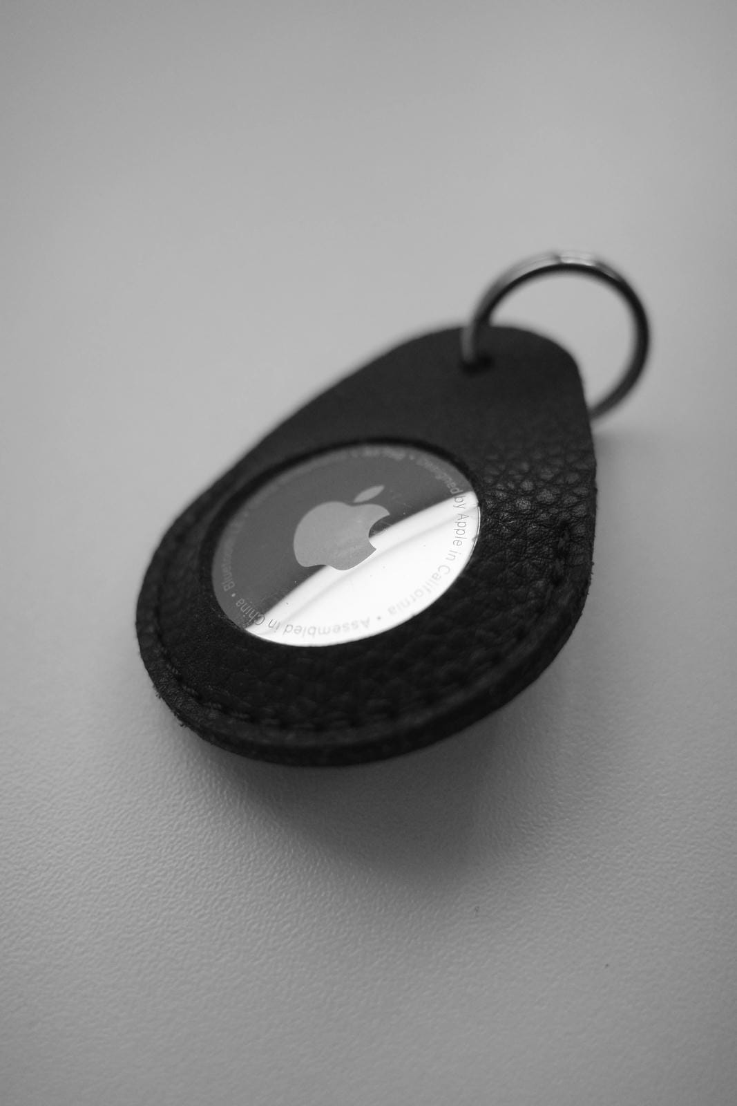 Black Apple AirTag case on a gray background
