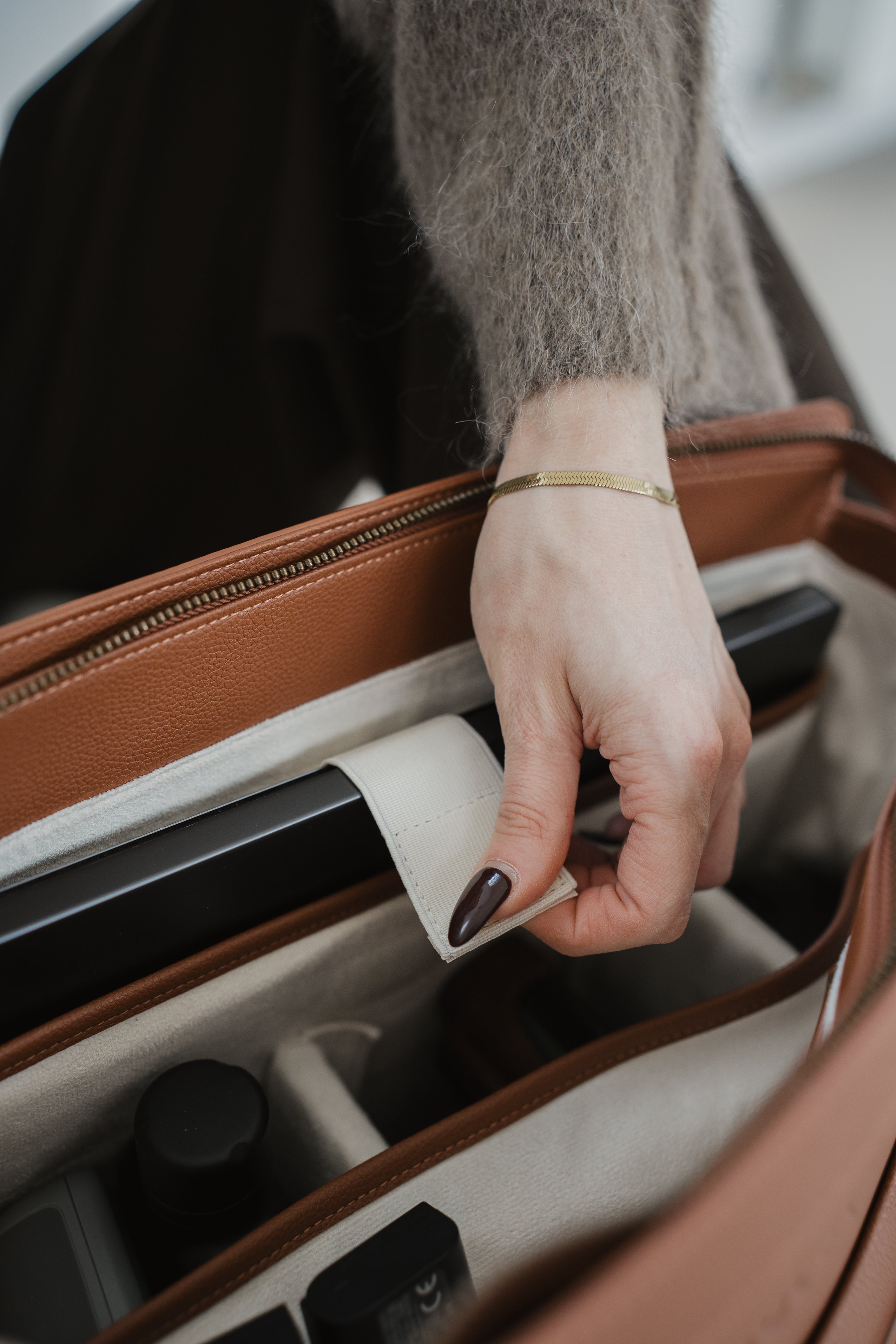 Hand opening a suitcase with a focus on the action of pulling the handle.