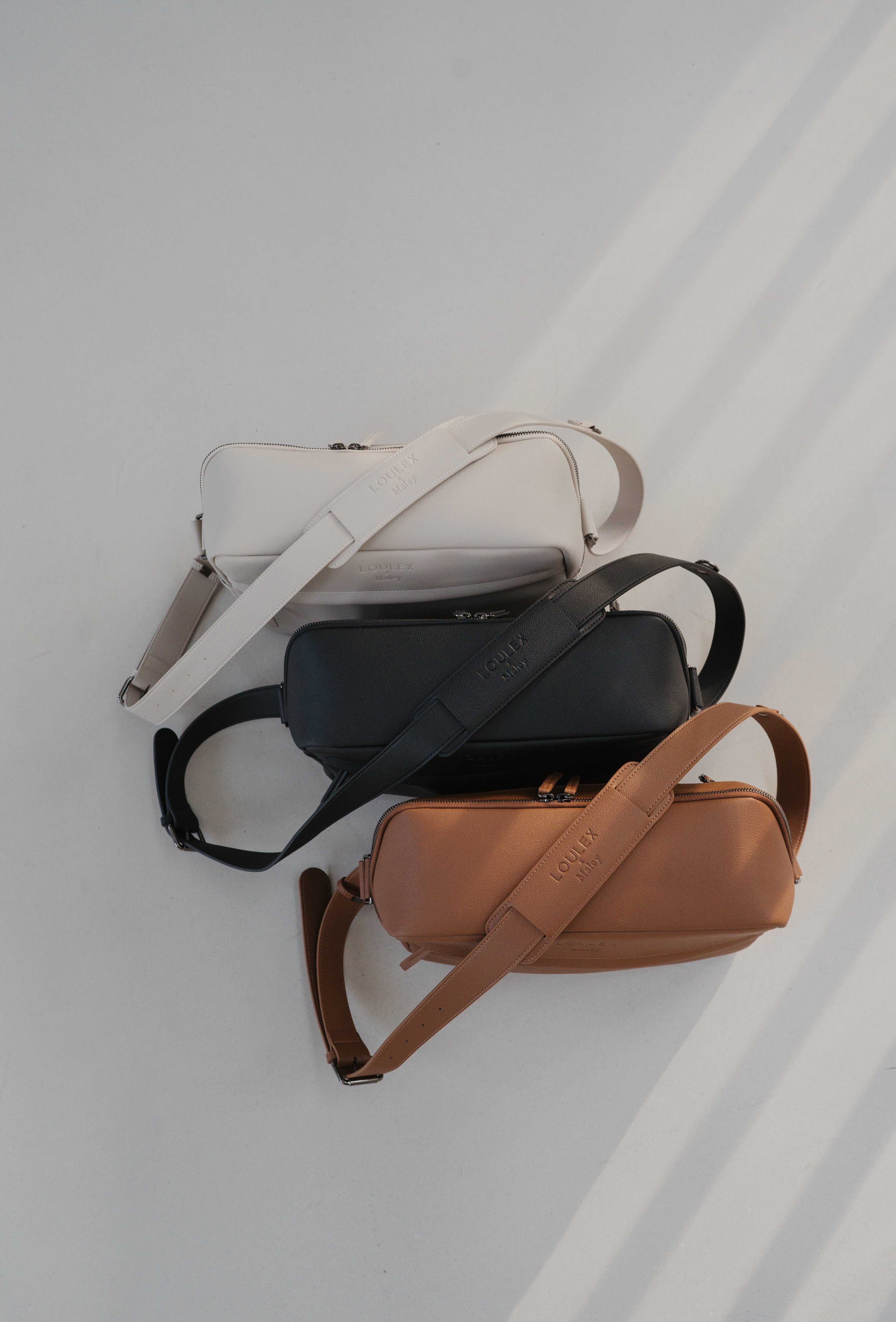 Three bags in white, black, and brown on a light gray background
