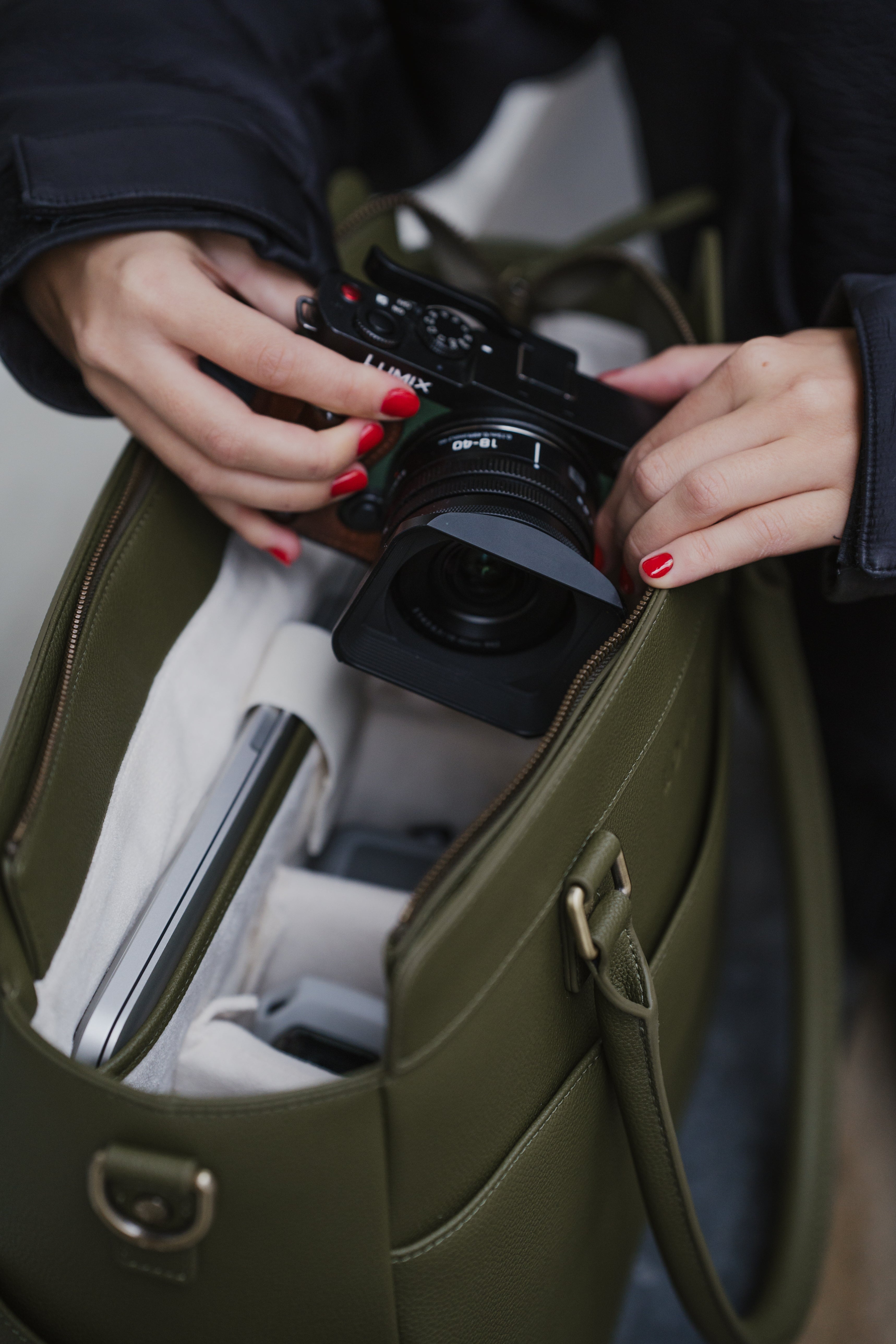 Person retrieving a camera from an open green bag
