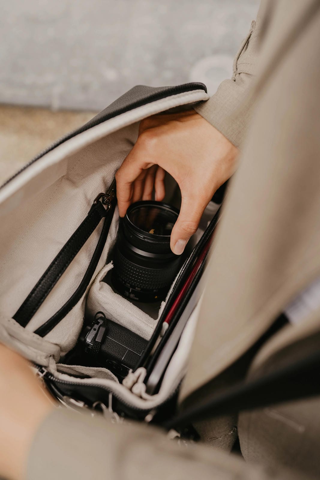 Person placing a camera into a bag with a blurred background