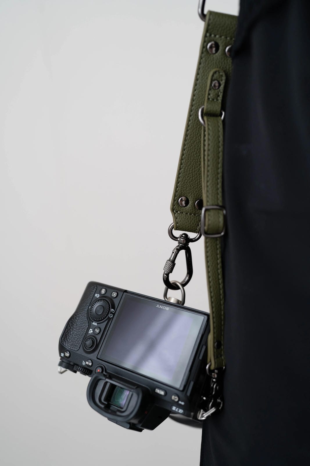 Camera with a green strap on a plain background