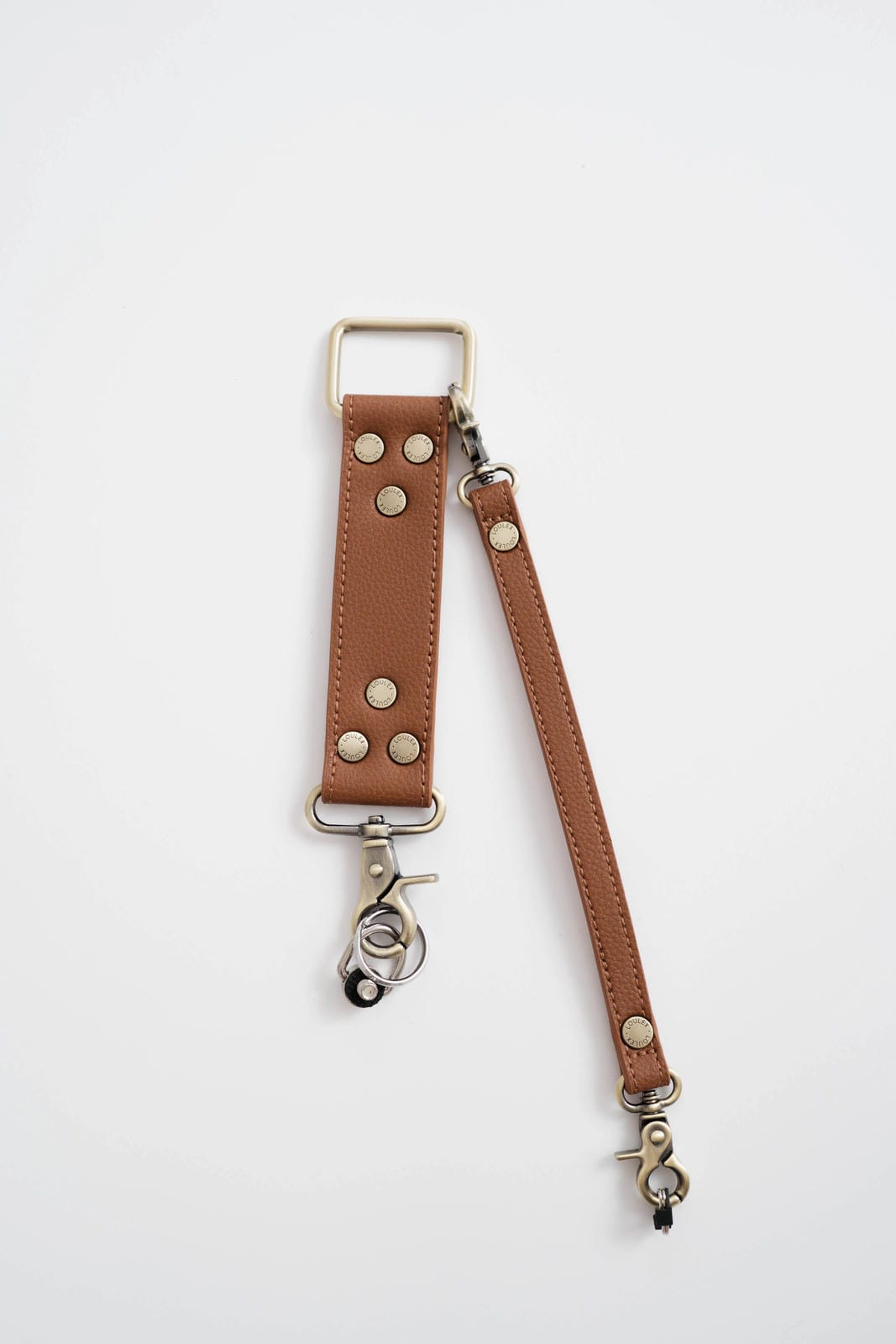Brown leather strap with metal hardware on a white background