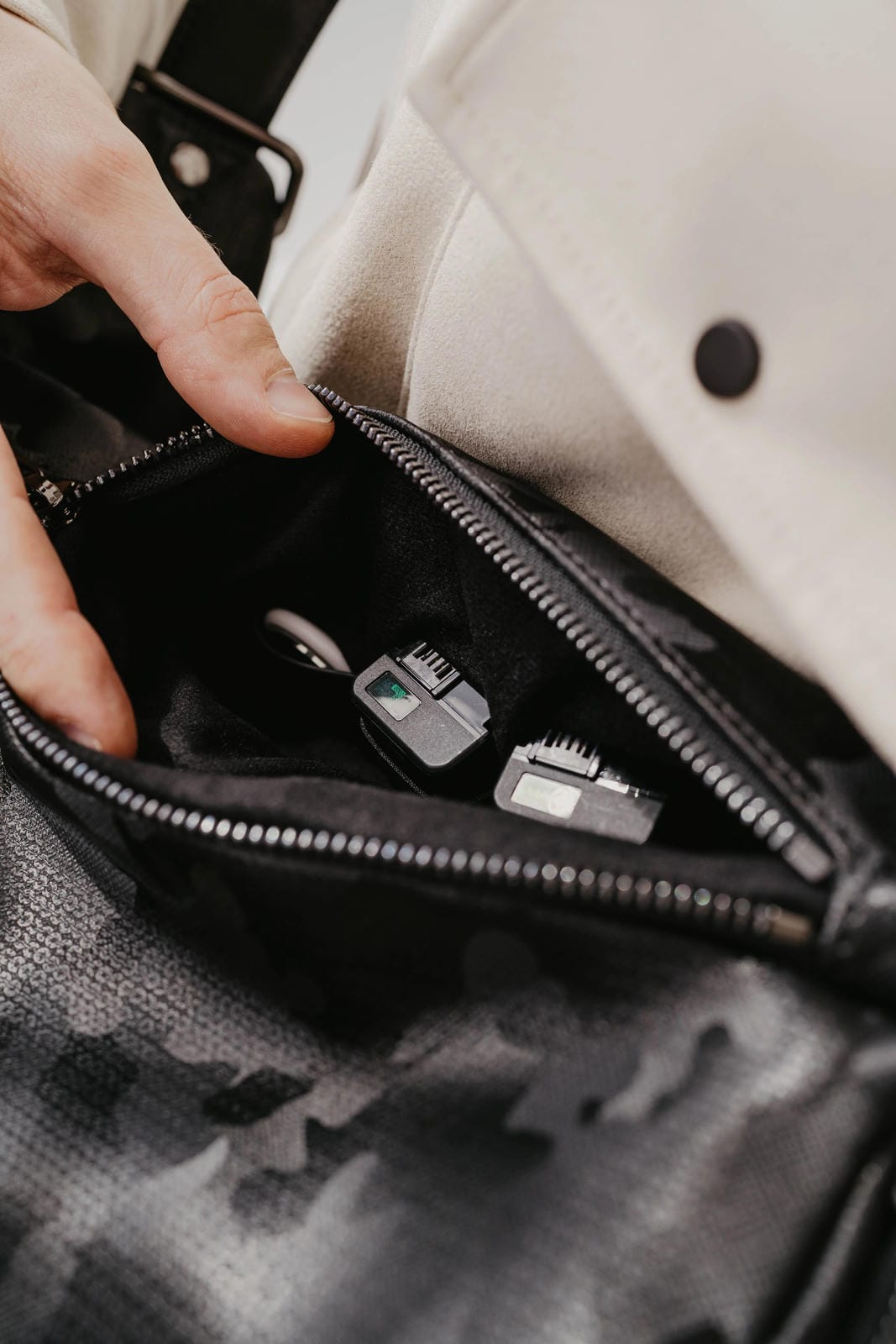 Person opening a black leather bag to reveal grooming products.