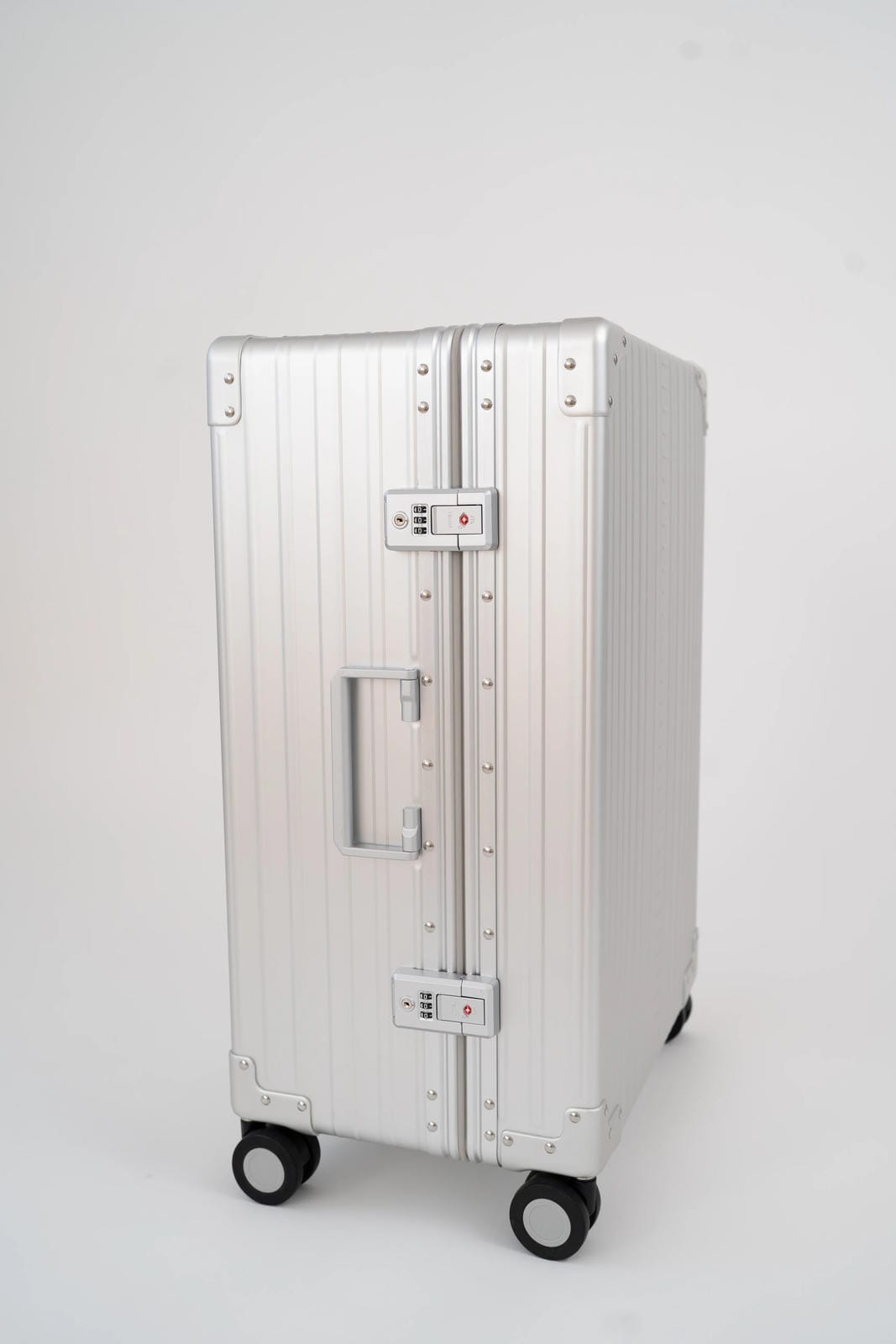 Silver suitcase with wheels on a white background