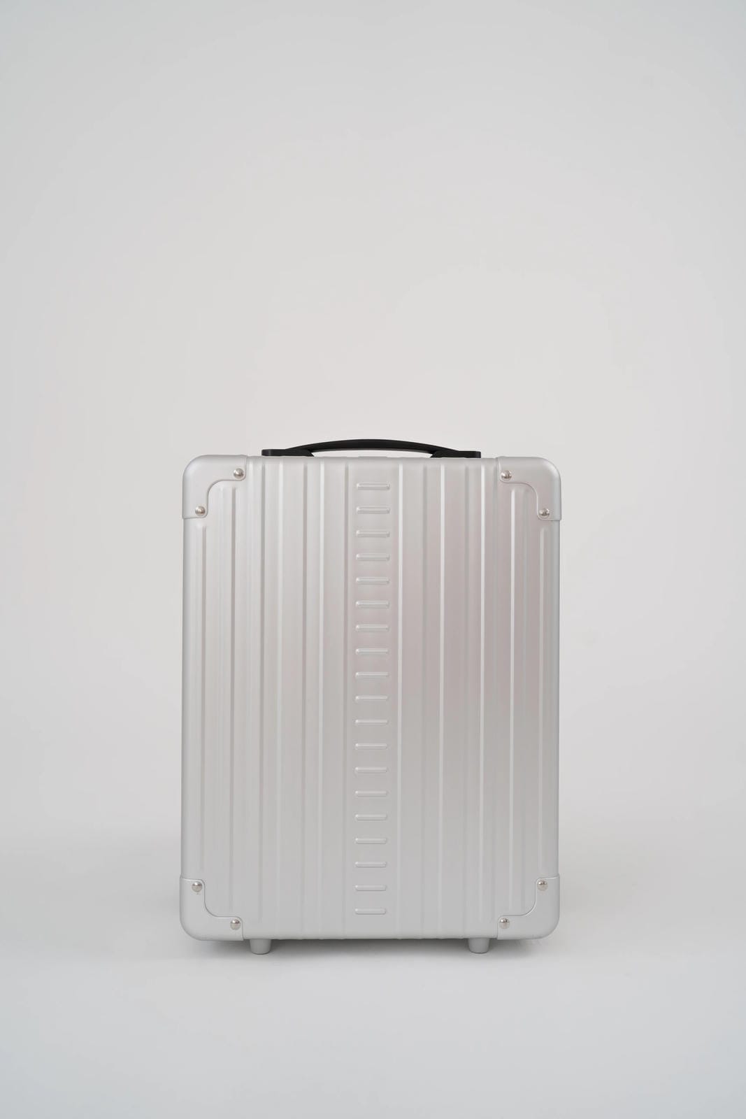 Silver suitcase with black handle on a white background