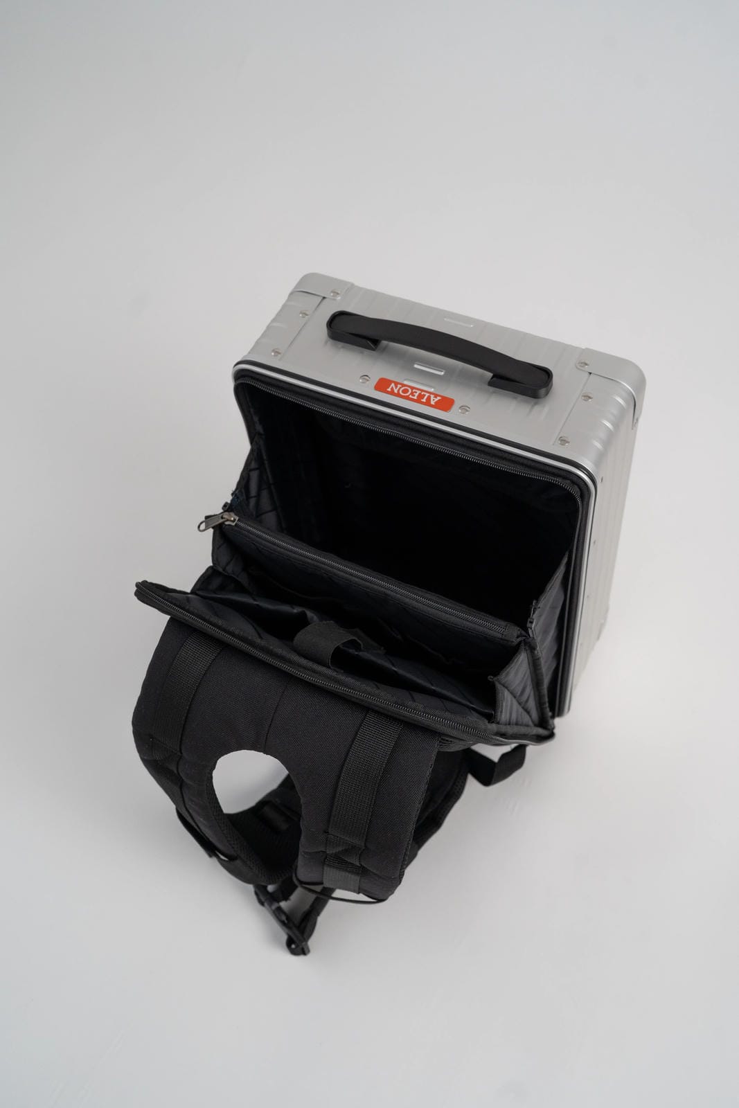 Gray suitcase with black interior and handle on a white background