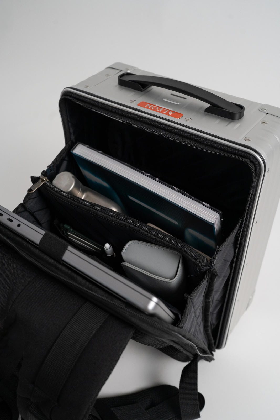 Open suitcase with travel accessories on a white background