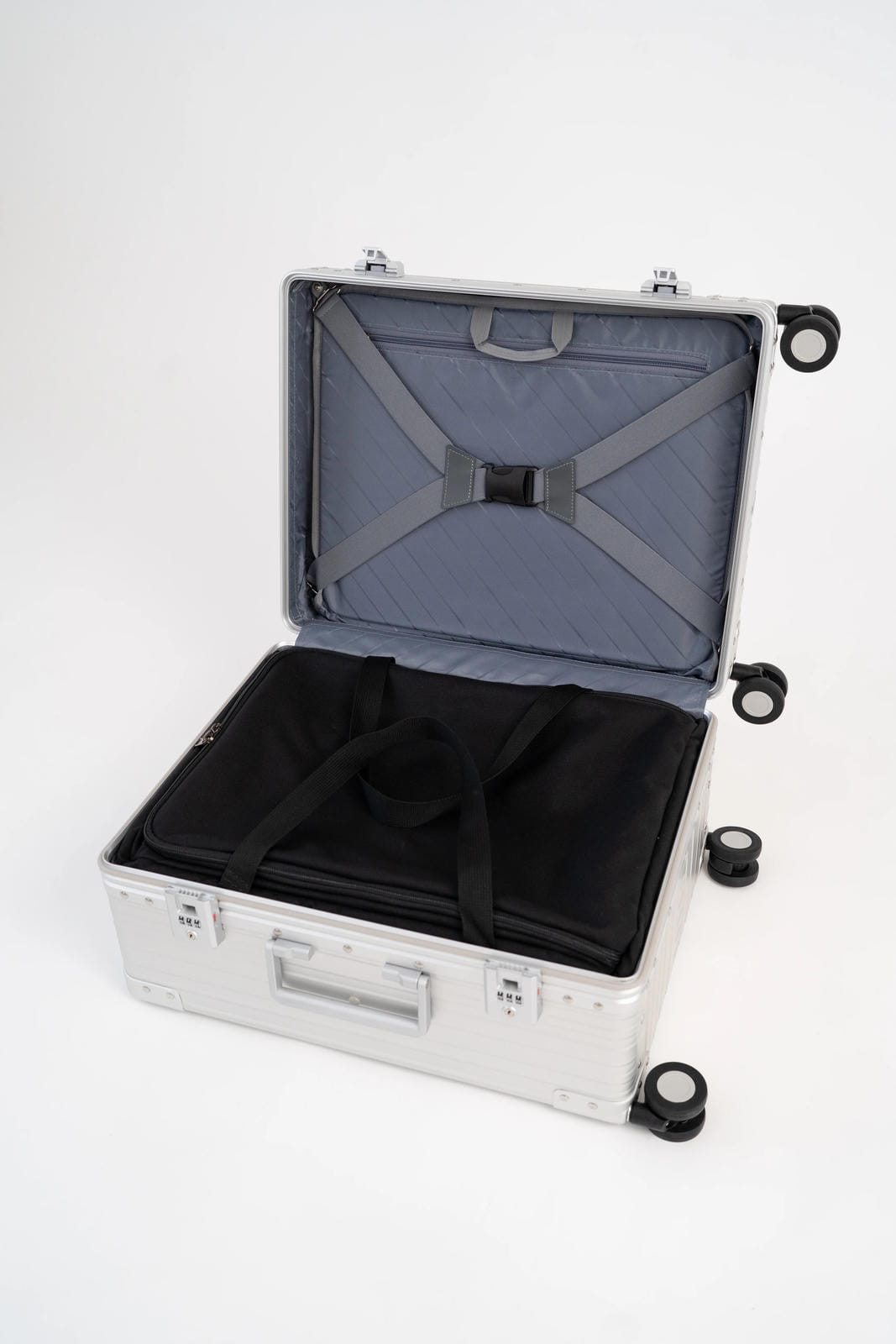 Open silver suitcase with black interior on a white background