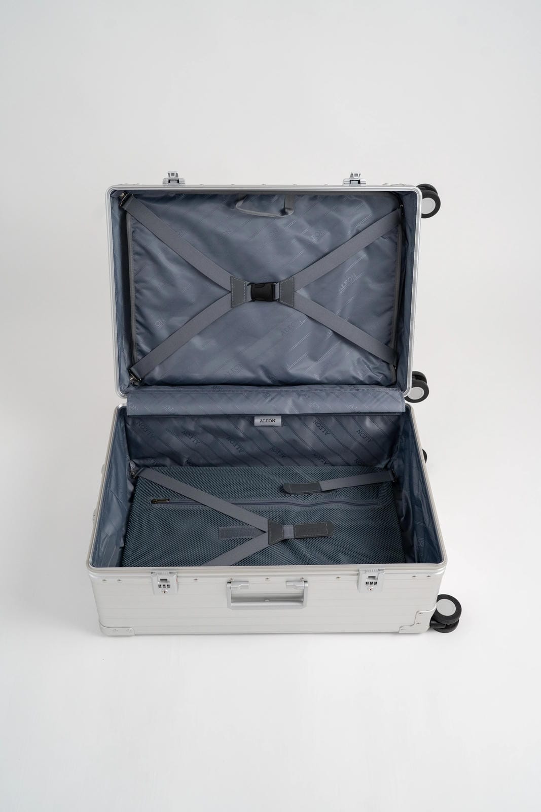 Open silver suitcase with black interior on a white background