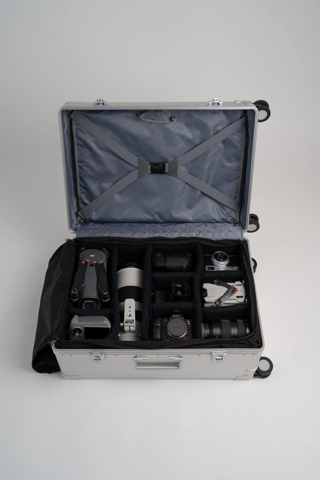 Open suitcase with camera equipment on a gray background