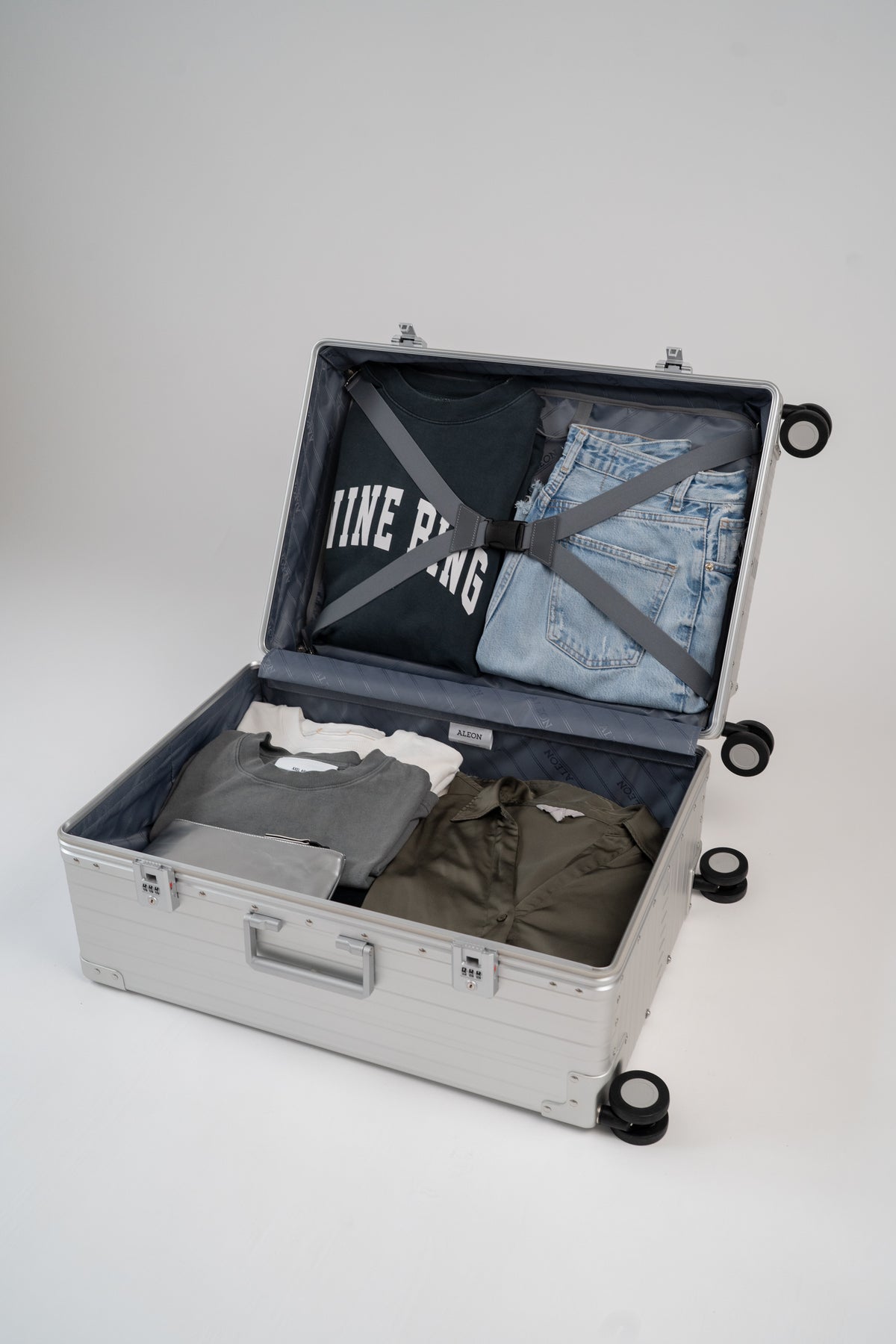 Open suitcase with clothes on a white background