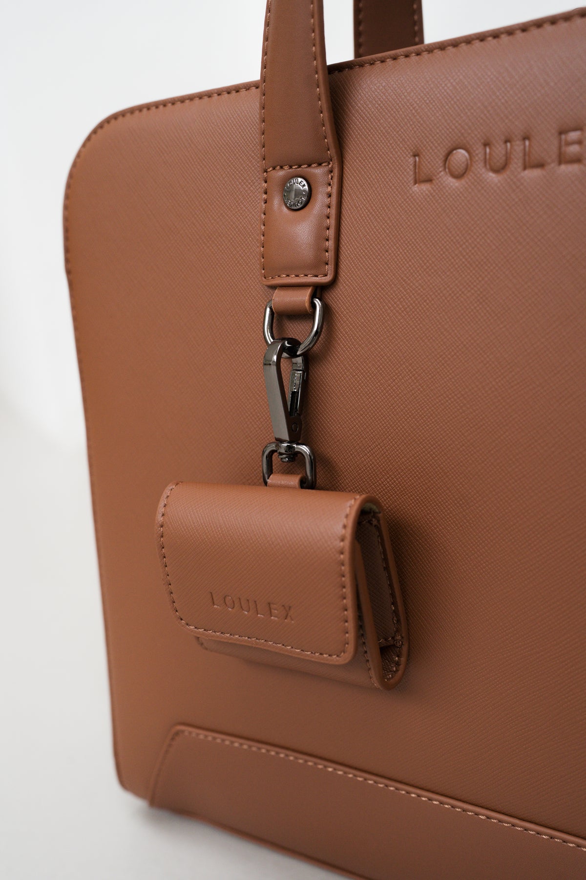 Brown handbag with a attached wallet and 'LOULE' branding on a light gray background