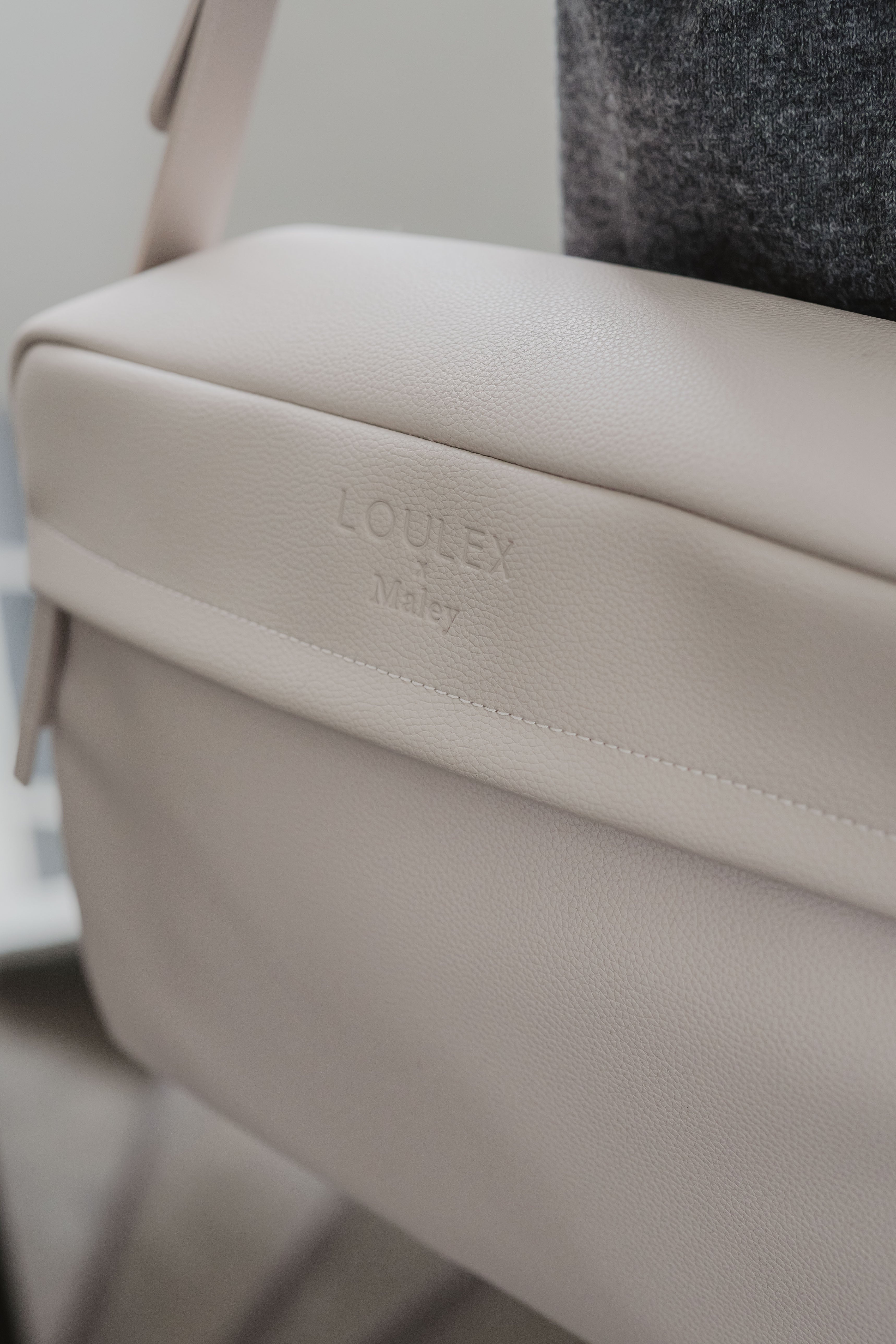 Beige bag with 'LOULEX' branding on a blurred background