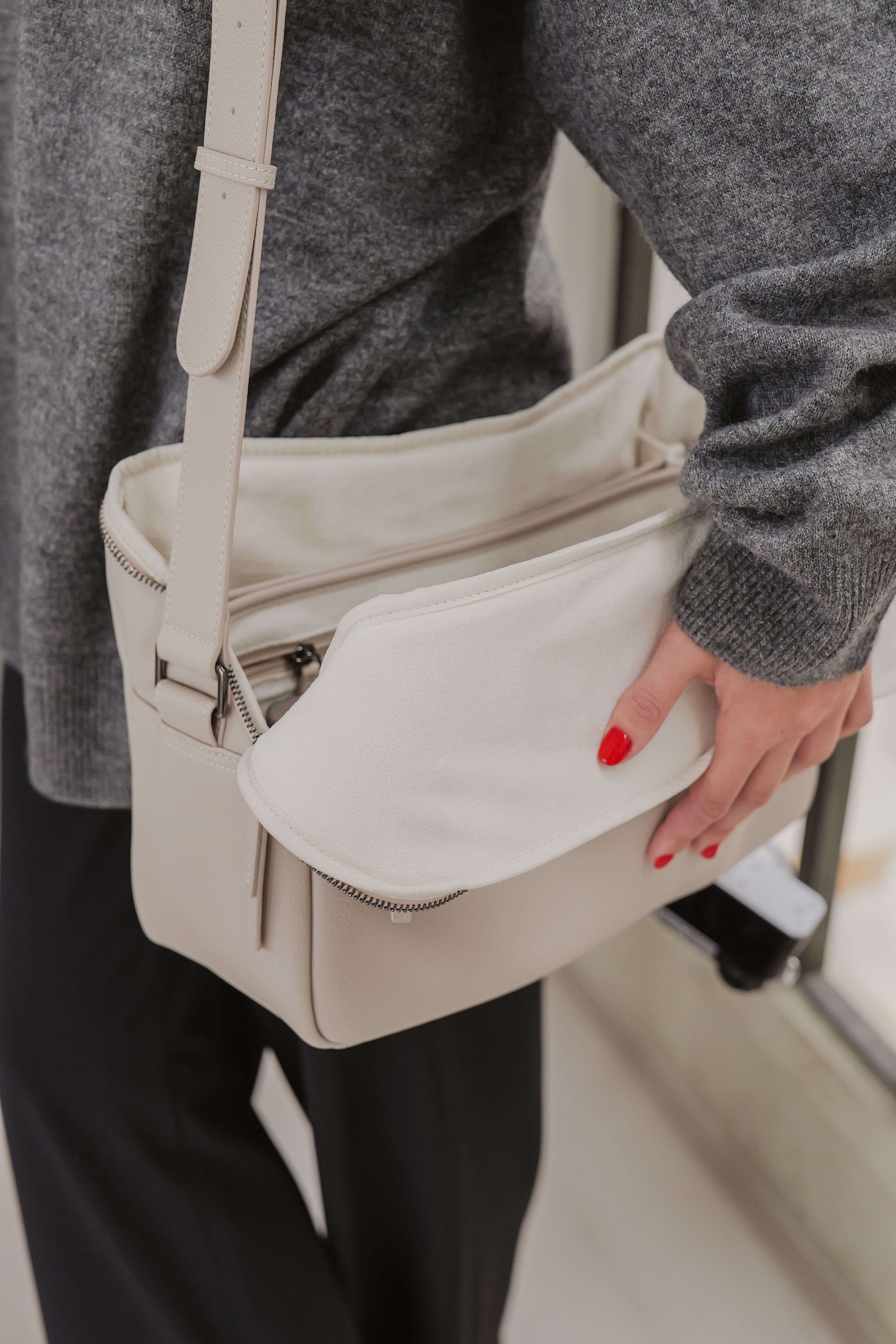 Person holding a beige handbag with a blurred background