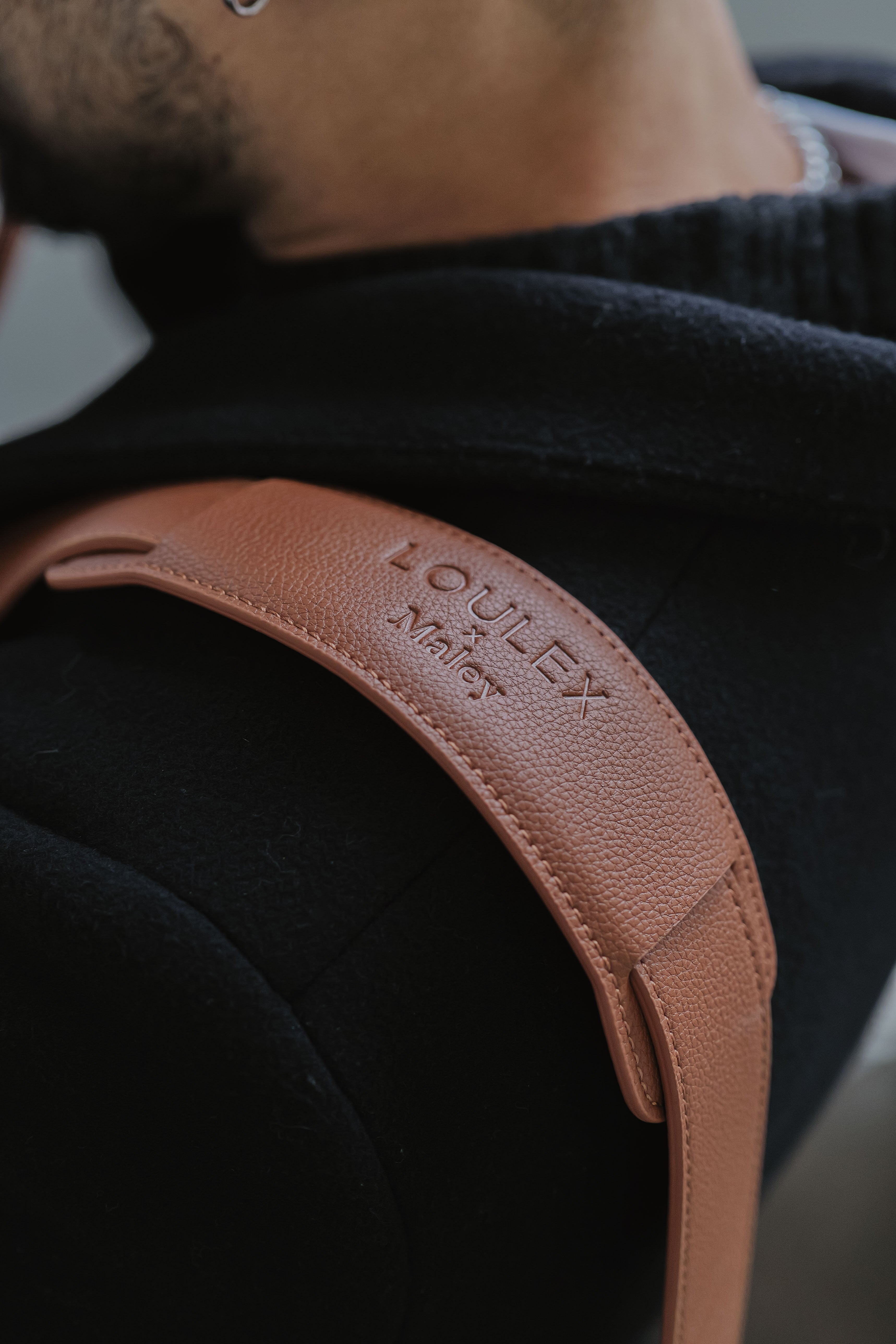 Brown leather strap with 'LOWLEY' branding on a dark background