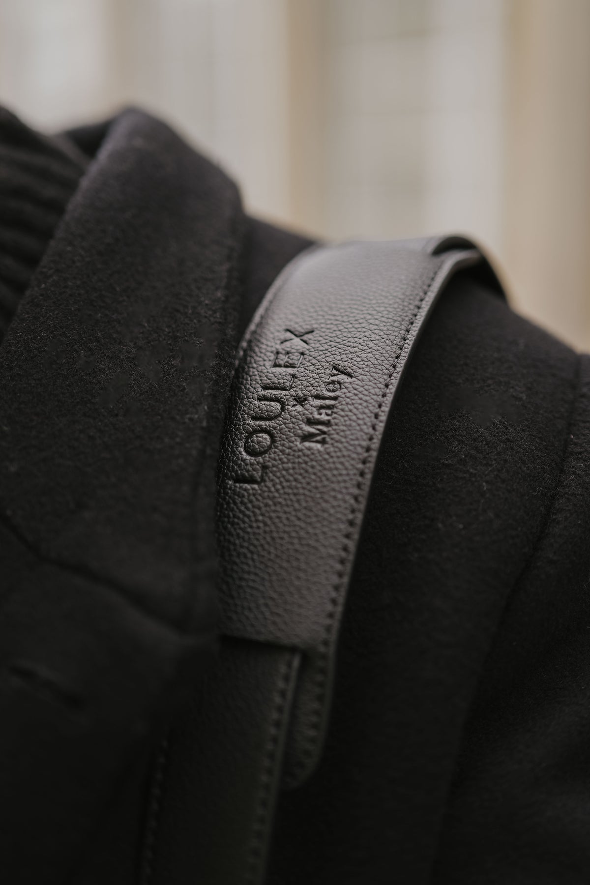 Close-up of a black jacket with a visible brand logo on a blurred background