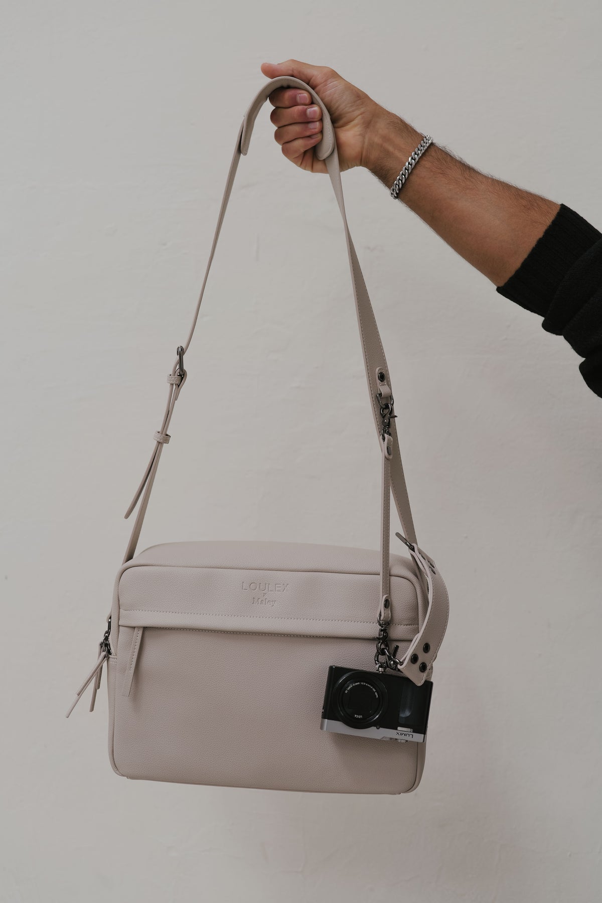 Beige handbag with a camera design on a plain background