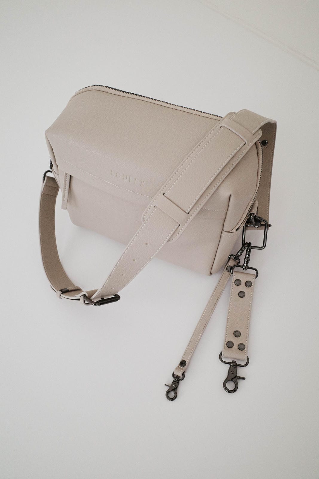 Beige leather bag with strap on a white background