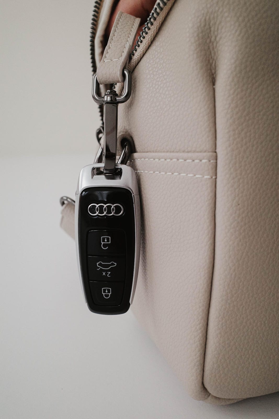 Audi key fob attached to a beige bag