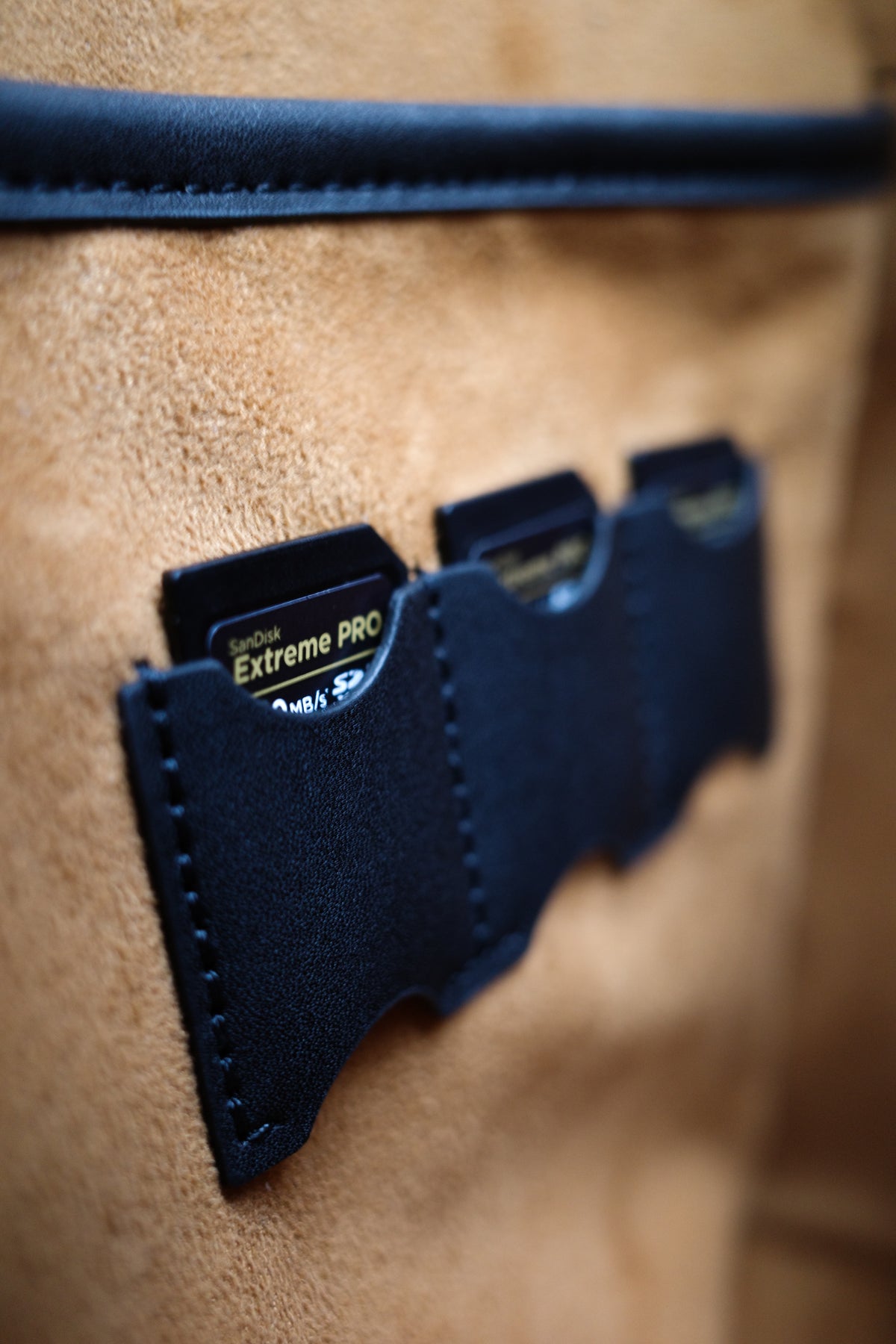 Close-up of a brown leather bag with a blue card holder featuring 'Extreme Pro' branding.